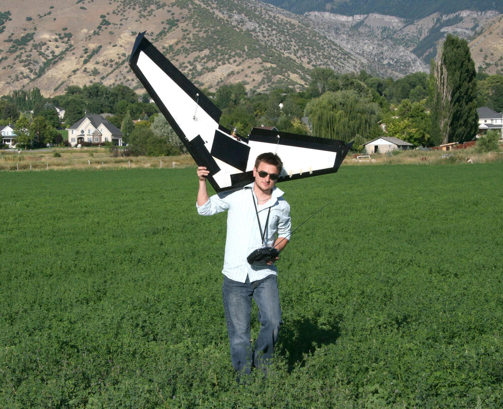 Posing with a plane model in a lush green farm field